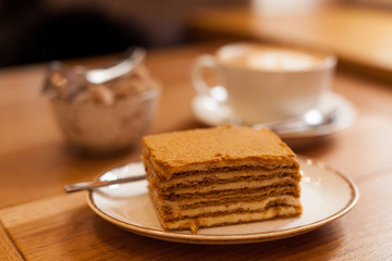 Piece of honey cake on a wooden table. Hygge concept.