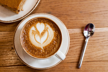 Cup of coffee on wood table, close-up. Cozy pastime in the cafe