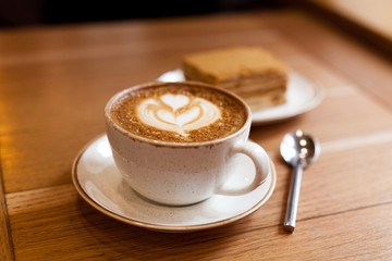 Cup of coffee on wood table, close-up. Cozy time in the cafe