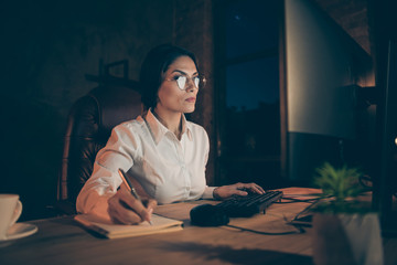 Portrait of her she nice attractive lovely stylish smart clever intelligent experienced lady shark expert specialist writing notes startup at night dark work place station indoors