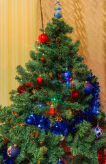 Fragment of artificial Christmas tree with decoration and Christmas lights