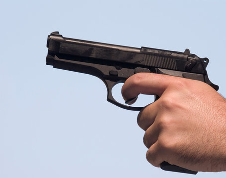 male hand holding a gun 