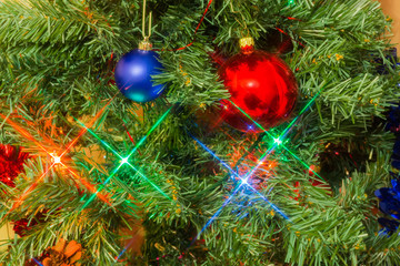 Fragment of artificial Christmas tree with decorations and Christmas lights
