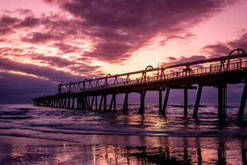 Jetty at sunrise with dramatic clouds