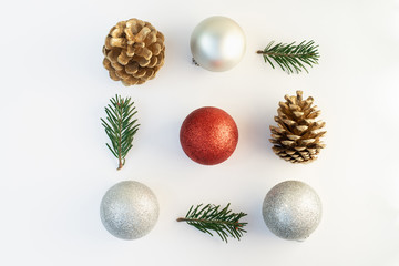 Christmas composition. Frame made of christmas tree branches, silver and red decorations, bumps on white background. Flat lay, top view, copy space