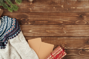 Warm sweater and Christmas gift on wooden background