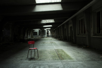 une chaise rouge dans un couloir abandonné horreur