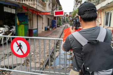 Male tourist taking photo of Hanoi railway next to the 
