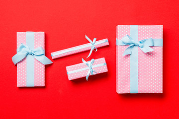 Fototapeta premium Top view Christmas present box with blue bow on red background