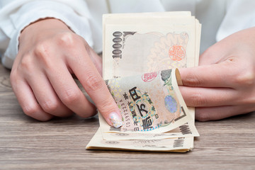 Close up female hand counting Japanese yen bank notes, Concept of banking, saving, currency,financial