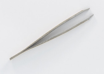 Metal tweezers to remove hairs from the face