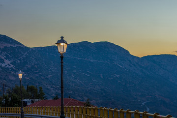 outdoor street lantern turn on in evening twilight time on atmospheric mountain background, copy space 
