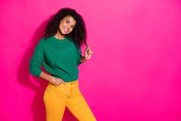 Portrait of lovely positive cheerful dark skin girl touch her skin have fun on winter holidays wear green knitted pullover yellow style pants isolated over bright color background