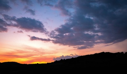 Evening sunset with trees over English countryside landscape from a hill peak.