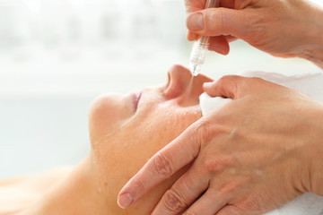 Oxygen oxybrasion. The beautician performs oxygen oxybrasion treatment on the skin of a woman's...