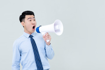 Asian man in business attrie shouting on megaphone