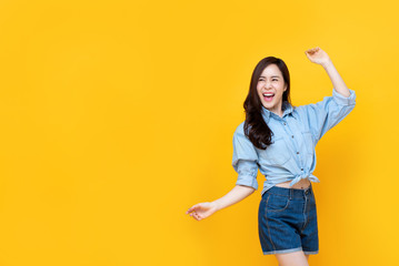 Excited pretty Asian woman smiling with arm raise