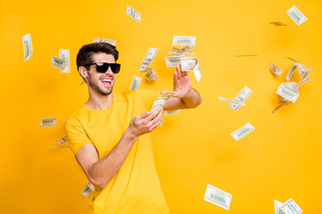 Photo of young handsome careless guy throwing usa money banknotes away wealthy person wear sun...