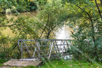 metal walkway to access jetty on the river with sun rays