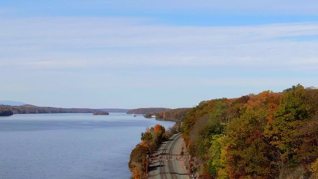 Rising aerial over train tracks on Hudson River New York colorful Autumn foliage