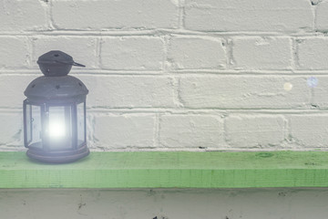Old vintge black rusty lantern  on green shelf, home interior decoration