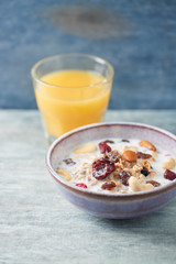 Tasty and healthy breakfast with granola and fresh orange juice. Rustic wooden background. Copy space. 