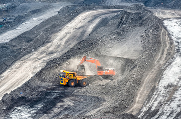 Coal mining in a quarry. A hydraulic excavator loads a dump truck.
