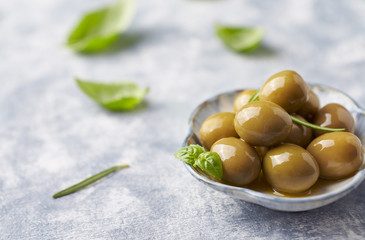 Green olives on bright wooden background. Close up. 