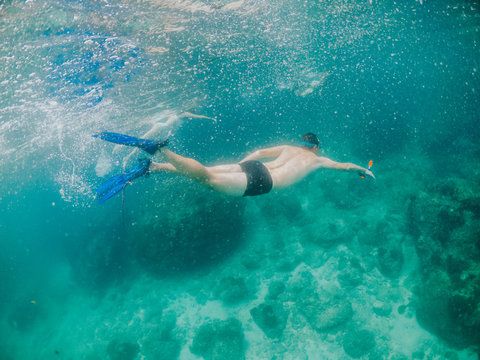 Split-view image of a swimmer enjoying clear water on tropical island. Summer lifestyle concept. 