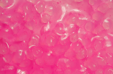 Obraz premium shiny pink slime texture with eggs inside. pink light with a wet sheen