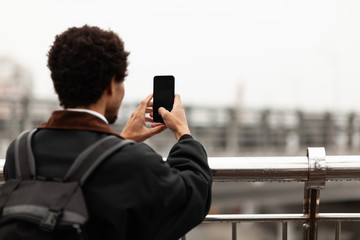 African man photographs on a smartphone. Blogger, reporter.