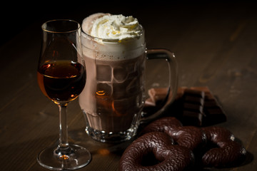 Heiße, dunkle Russische Trinkschokolade mit Sahne, Rum, Lebkuchen, Schokoladentafel auf dunkel Holz Hintergrund 