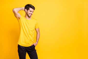 Photo of cheerful handsome attractive man having fun relax resting smiling toothily beaming wearing black trousers yellow t-shirt isolated over yellow vivid color background