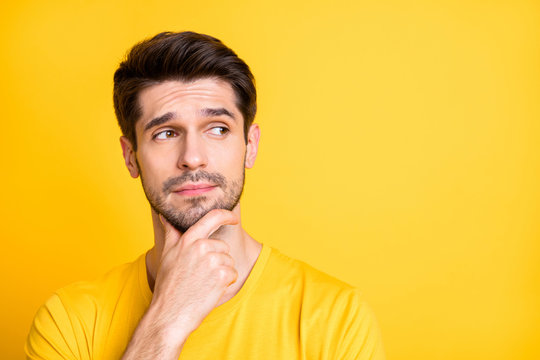 Close-up portrait of his he nice attractive lovely doubtful brown-haired guy thinking touching chin creating new idea isolated over bright vivid shine vibrant yellow color background