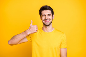 Close-up portrait of his he nice attractive cheerful cheery guy wearing tshirt showing thumbup ad...