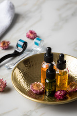 Dermaroller, Handtuch und Beauty Naturkosmetik Serum Öl Flasche zum  Microneedling für Anti Aging Lifting oder Akne Anwendung auf Marmor Hintergrund