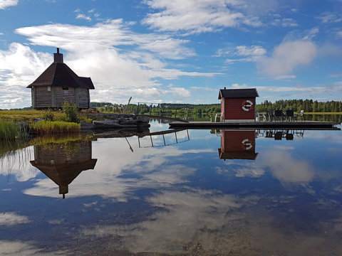 Swedish lake Gaxsjon with reflections on the calm water and a sauna house on the islet