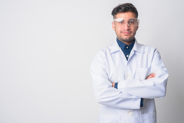 Portrait of young Persian man doctor as scientist with arms crossed - obrazy, fototapety, plakaty