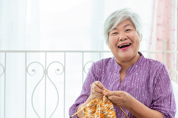 Happy senior woman female knitting at home as hobby