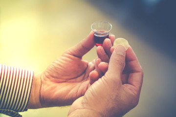 Man holding bread and wine in a Holy communion.