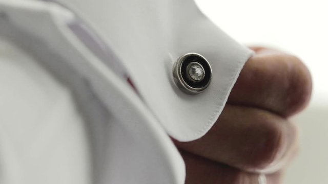 Sposo mentre si abbottona il colletto della camicia nella sua camera da letto