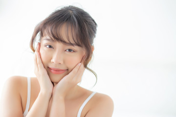 Portrait of beautiful young asian woman smile while wake up healthy and wellness with sunrise at morning in the bedroom, asia girl skin care with happy with fresh, lifestyle and relax concept.