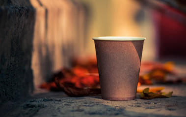 paper coffee cup at fall season faded leafs background