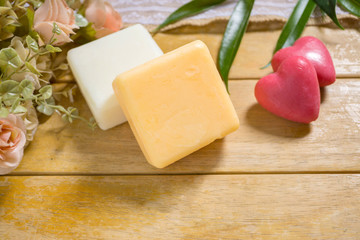 Natural handmade soap with flower and leaf on wood.