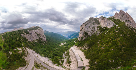 Fototapeta na wymiar Aerial view of winding road surrounded by mountains, beautiful roads for traveling by motorcycle or car, the way of hikers and and cyclists, Falzarego Pass, Dolomites, Italy. Cortina d’Ampezzo.
