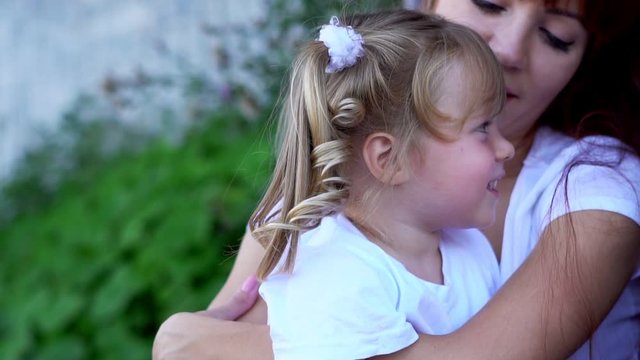 mom hugs her daughter holds in her arms