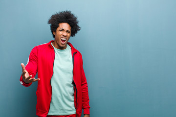 young black sports man looking angry, annoyed and frustrated screaming wtf or what‚Äôs wrong...