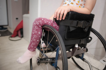 close-up hand of a child on a wheel from a wheelchair. Disabled children concept.