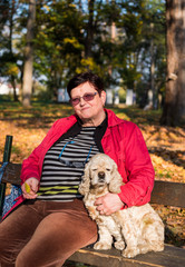 Woman with american spaniel sitting on the bench