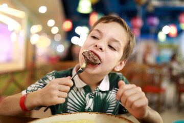 Child eating veal cutlet
